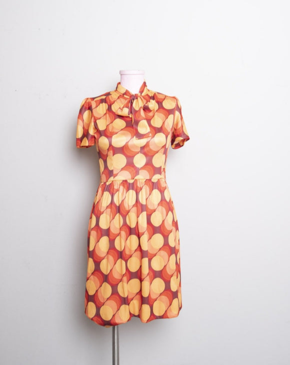 1970's inspired Brown and orange short sleeve mini dress with bow tie in a abstract circular print