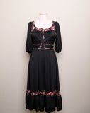 1970's Black prairie style puff sleeve dress with floral trim and corset lacing on bodice
