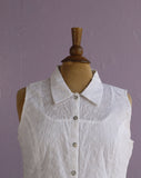 White sleeveless top with floral embroidery.