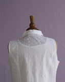 White sleeveless top with floral embroidery.